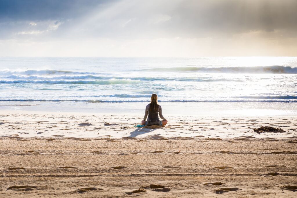 woman at beach doing daily meditation practice
